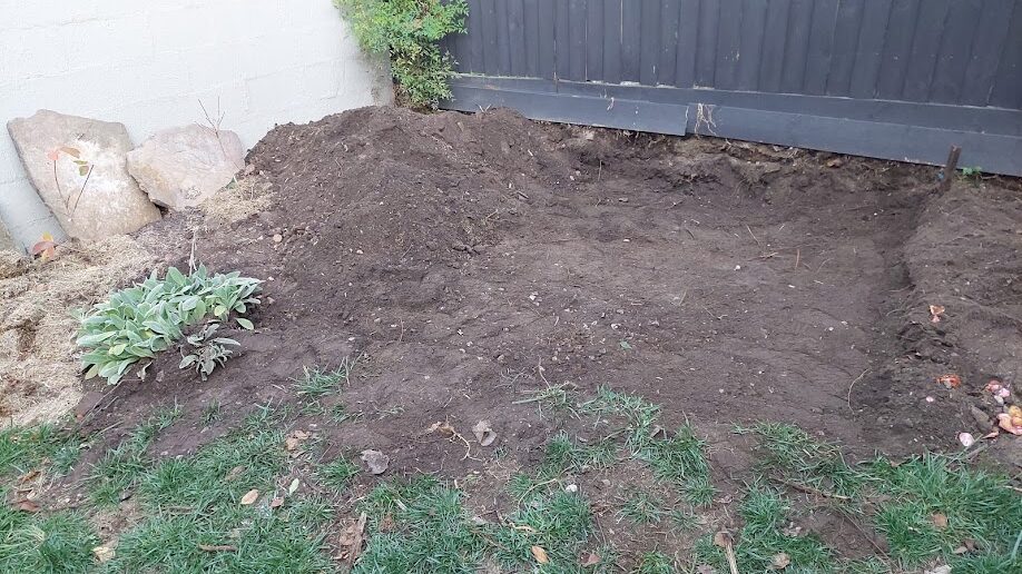Before: Flagstone paving. Bare, dug-over ground laid with flagstones and planted out.
