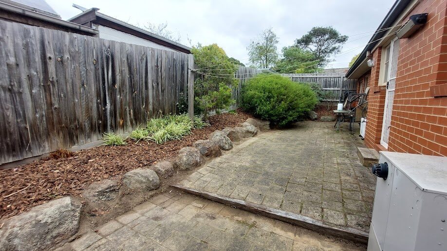 After: Paving and bed edge. Weeds cleared out of the paving and the bed mulched back to a clean line.
